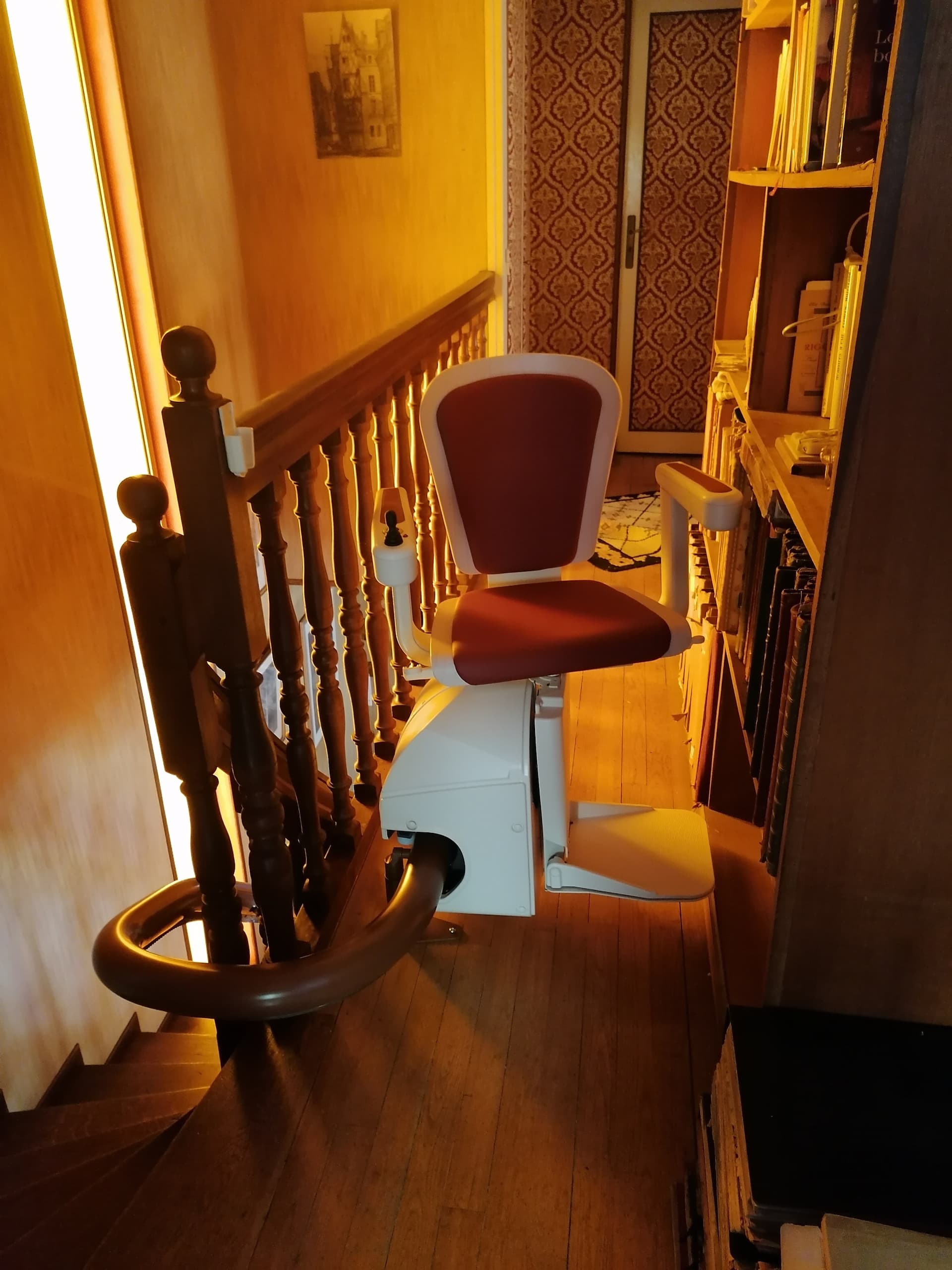 Fourniture et pose d’un monte escalier courbe monorail. Assise modèle alliance de coloris rouge. Réalisation sur la commune de Angers