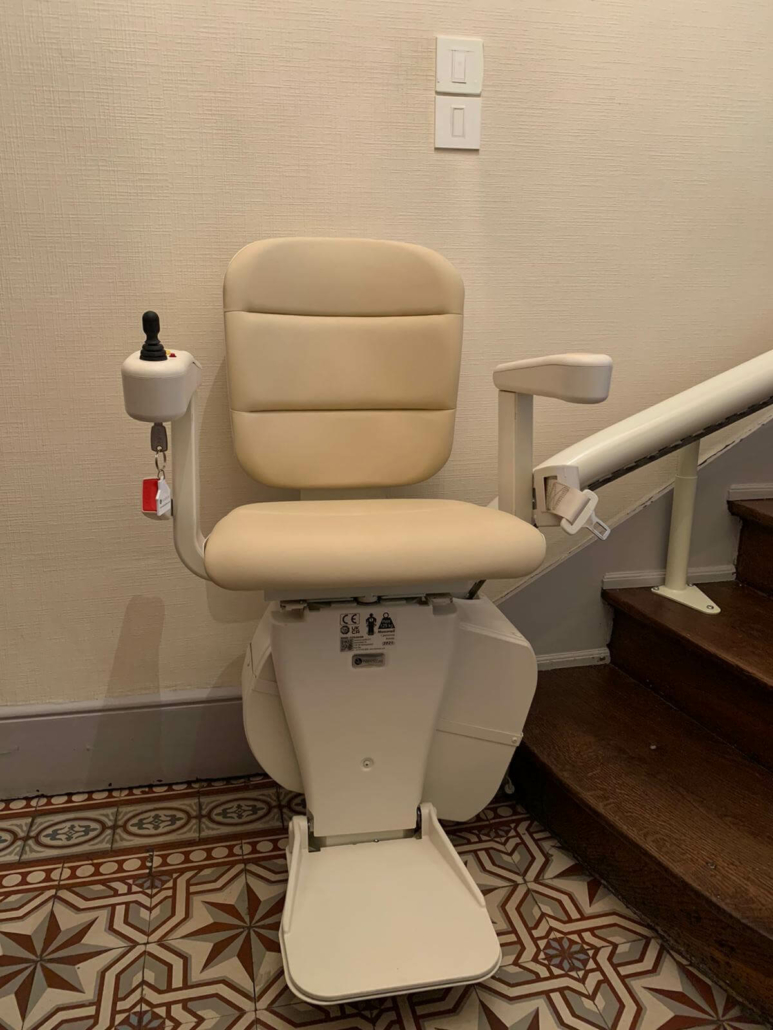 Monte-escalier courbe monorail, siège de couleur beige. Installation réalisée à Angers