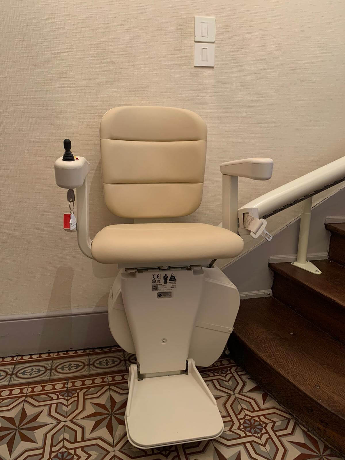 Monte-escalier courbe monorail, siège de couleur beige. Installation réalisée à Angers